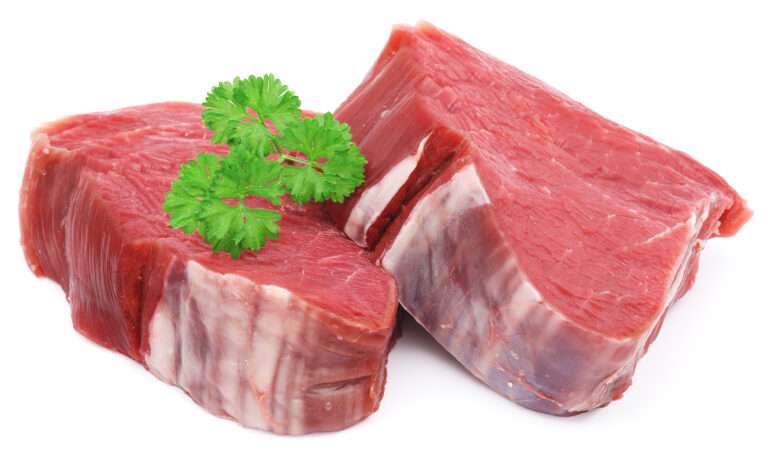 Zwei rohe Rindersteaks, garniert mit Petersilie. Fleisch.